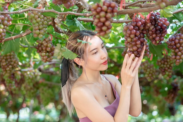 Woman relaxing with nature, grapes in vineyard.