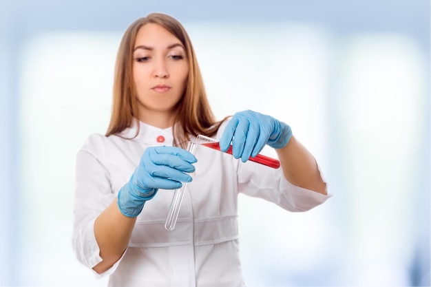 Woman researcher is surrounded by medical vials and flasks isolated on white background