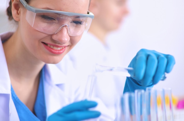 Woman researcher is surrounded by medical vials and flasks isolated on white