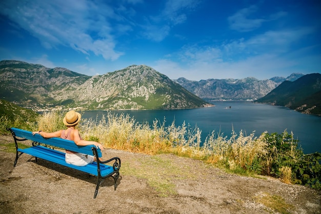 Woman resting on a bench in the romantic spot in mountains of the Bay of Kotor