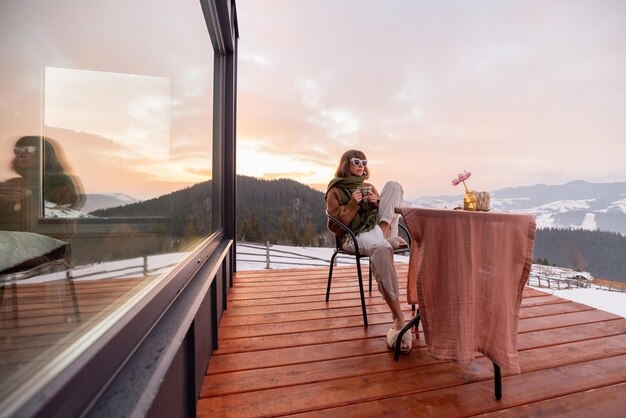 Photo woman resting on house terrace in the mountains