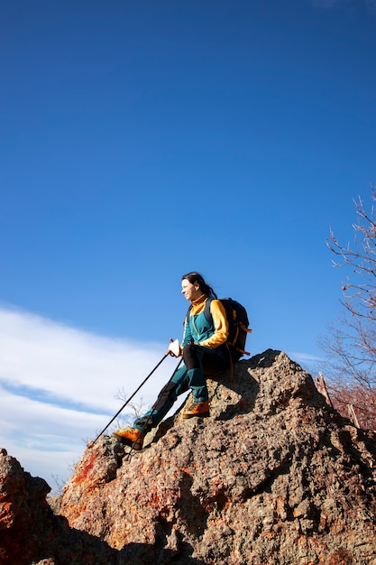 Woman resting on a rock during her hike in the beautiful outdoors