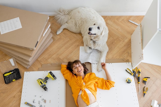 Woman rests with her cute dog while making repairing at new apartment