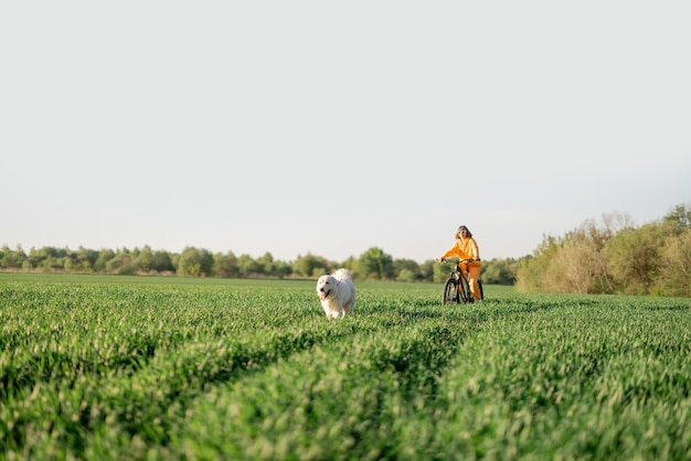 Woman rides a bicycle on a field