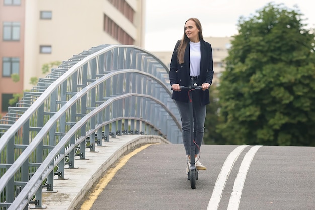 A woman rides an electric scooter in the city Popular urban transport