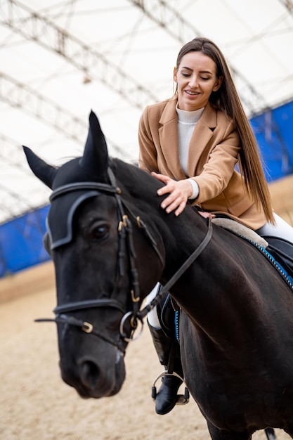 A woman riding on the back of a black horse