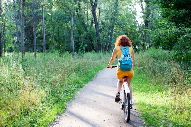 Woman riding a bike in green forest