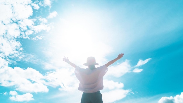 Woman rise hand up to amazing blue sky feel never give up and freedom