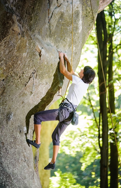 Woman rock climber on her challenging way up, bouldering