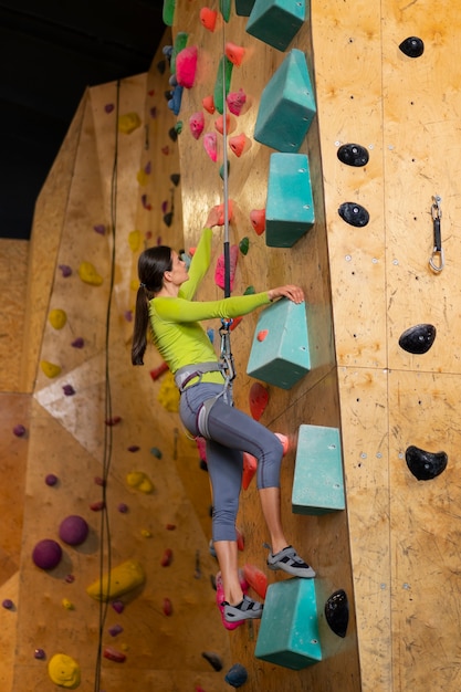 Woman rock climbing indoors in the arena