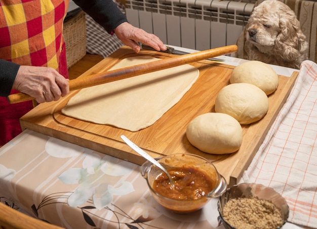 Woman rolling dough on a wooden board