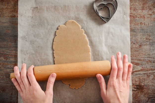 Woman rolls the dough with a rolling pin 