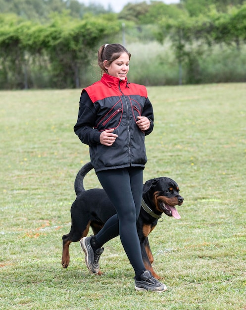 Woman and rottweiler in nature