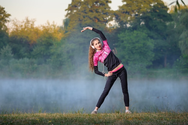 woman runner on foggy morning near lake