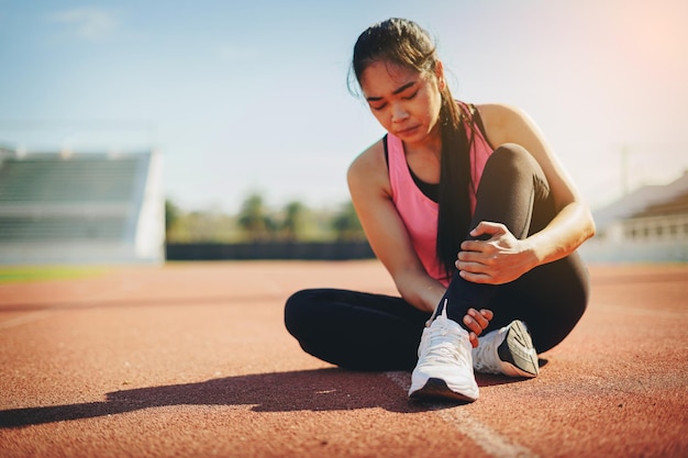 Woman runner has twisted ankle injury for practice marathon run at the racetrack