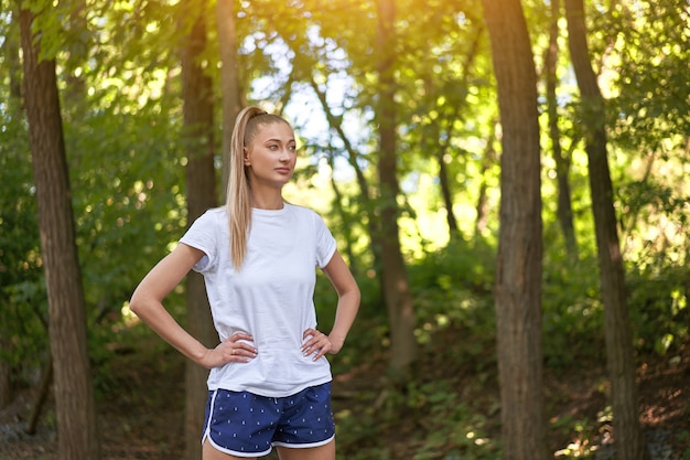 Woman runner standing before exercising summer park  morning