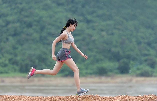 a woman running in a park with a shirt that says shes a runner