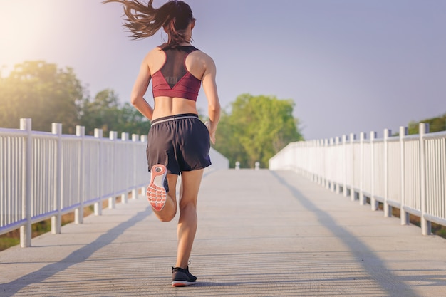 Woman running sprinting on road. Fit female fitness runner during outdoor workout