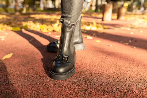 A woman's black boot is shown in a park.