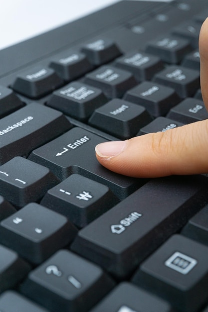 A woman's finger holding a computer keyboard