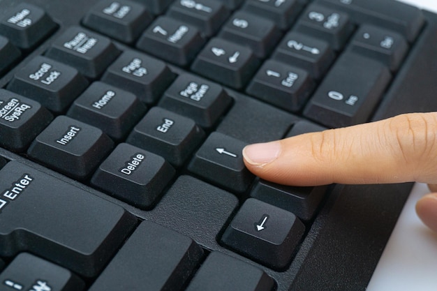 A woman's finger holding a computer keyboard