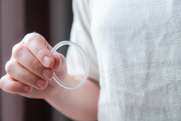 Woman's hand holding a birth control ring, vaginal ring for contraceptive close-up