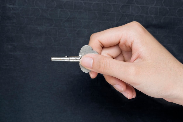 Woman's hand holding a key to open the door