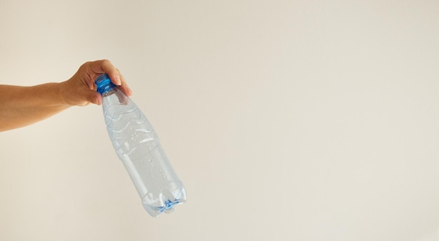 Woman's hand holds an empty plastic bottle