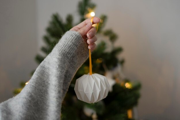 A woman's hand holds a handmade toy for the Christmas tree