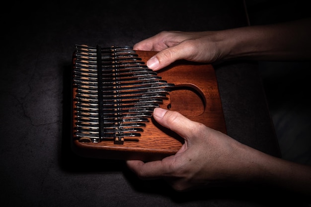 A woman's hand holds a Kalimba or mbira an African musical instrument