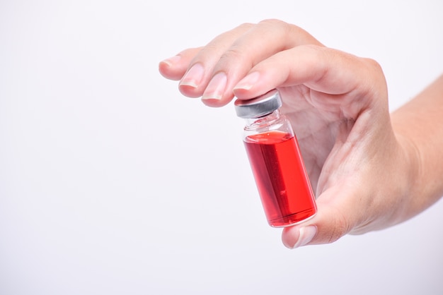 A woman's hand holds an medical vial or ampoule. Vaccine. The ampoule with the medicine. Medication for injection.