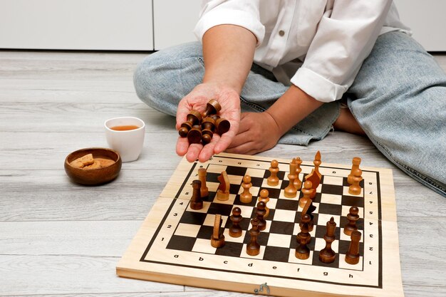 a woman's hand holds out the opponent's lost pieces in chess