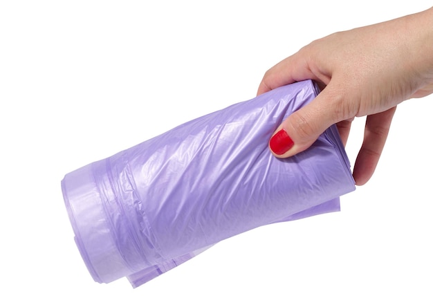 A woman's hand holds a roll of plastic bags for the trash can on a white isolated background