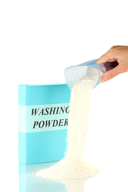 Woman's hand pours out of washing powder measuring cup on white background closeup