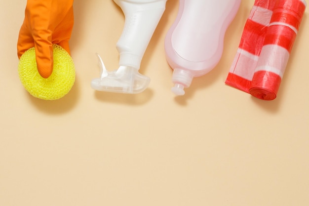 Woman's hand in protective glove with a sponge on the beige background