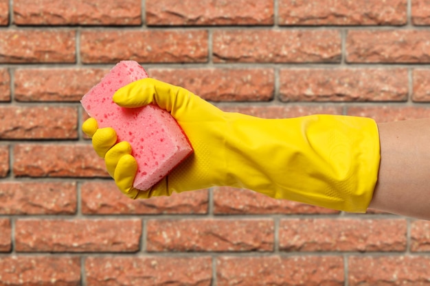 Woman's hand in protective glove with sponge