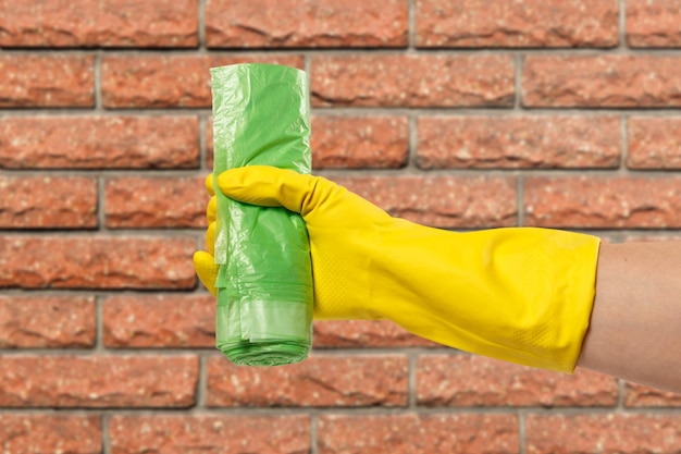 Woman's hand in protective glove with trash bags