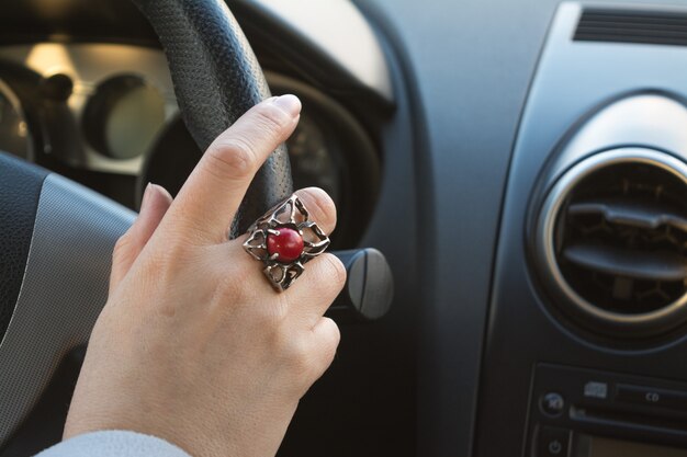 Woman's hand on the steering wheel of a car while driving