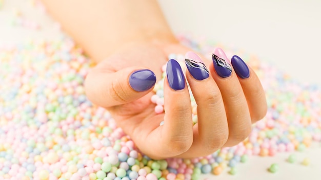 Woman's hand with polish nails Crop unrecognizable person showing manicure Concept of care and beauty Macro