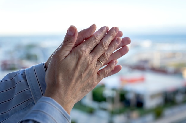 Woman's hands on the balcony to applaud medical staff for the fight against the coronavirus