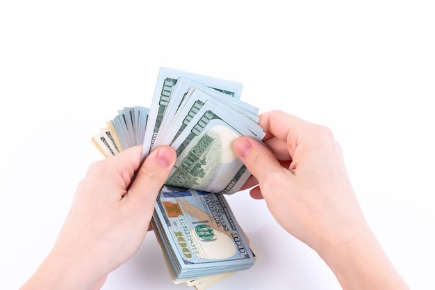 Woman's hands, count money, American one hundred dollar bills. Isolated on white. Copy space.