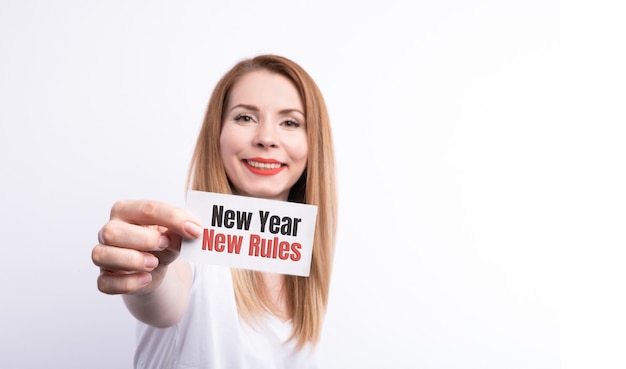 Woman's hands holding a note with new year new me text.