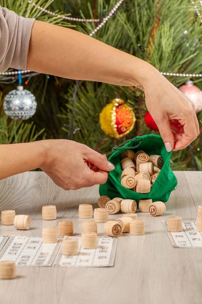 Woman's hands holding wooden barrels for a game in lotto