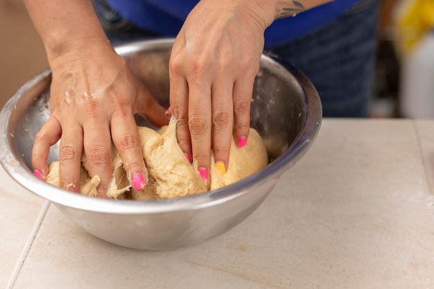 Woman's hands kneading ingredients to make pan de muerto