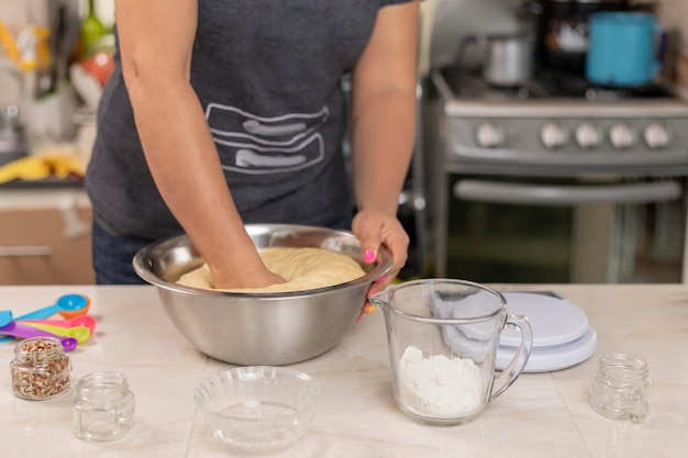 Woman's hands kneading ingredients to make pan de muerto