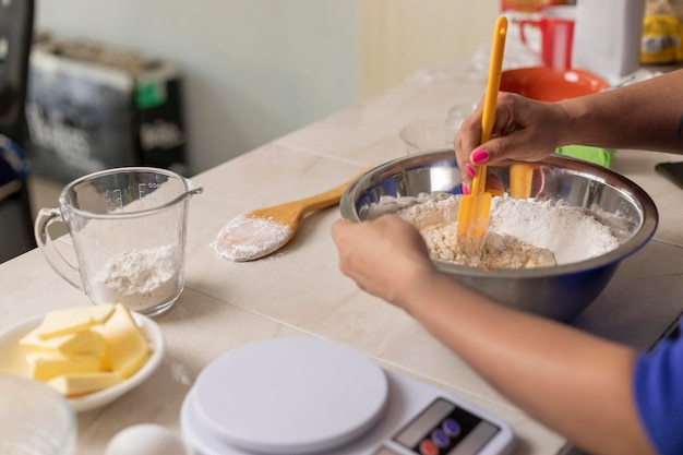 Woman's hands mixing ingredients in a bowl with a spoon to prepare bread