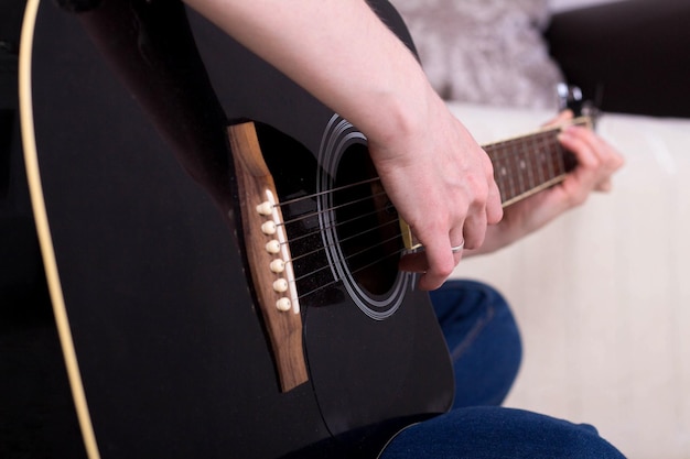 Woman's hands playing acoustic guitar