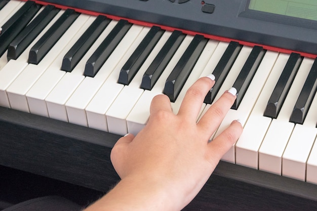 Woman's hands playing on electric piano