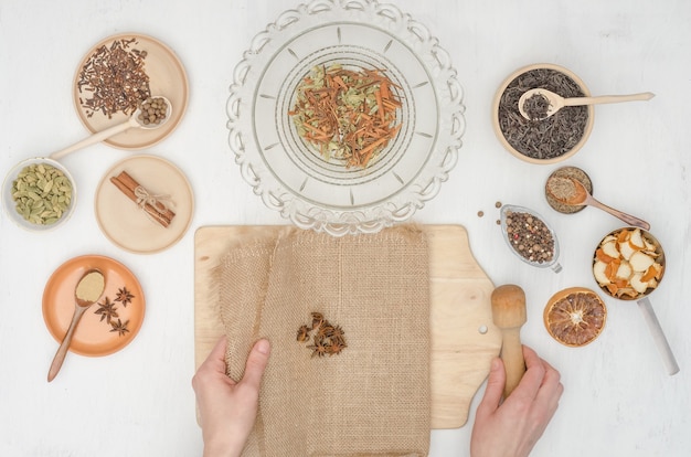 Woman's hands preparing Indian masala tea with spices