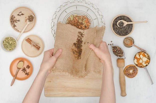 Woman's hands preparing Indian masala tea with spices